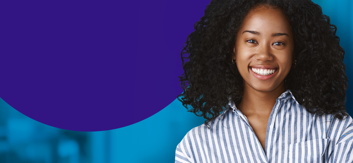 Woman similing with a blue and white stripped button up shirt.