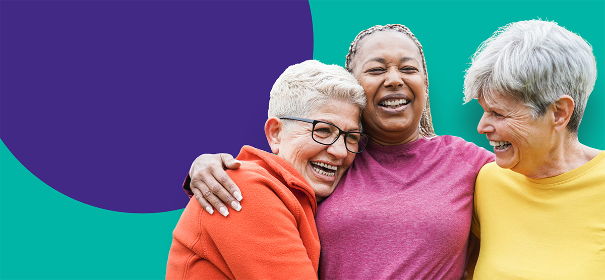 Three woman hugging and lauging.